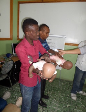 2 men learning CPR on baby