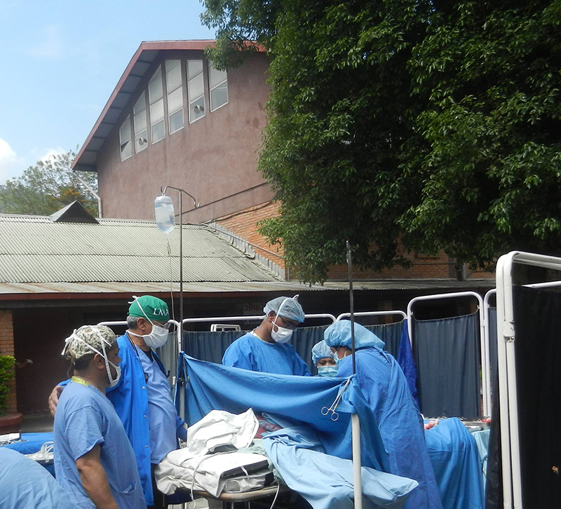 Photo taken the day of the earthquake: Drs. Vidya Prodhananga, OB-GYN, and Ramon Ruiz Diaz, anesthesiologist, and their team perform a cesarean section outside of Scheer Memorial during the aftershocks of the earthquake.