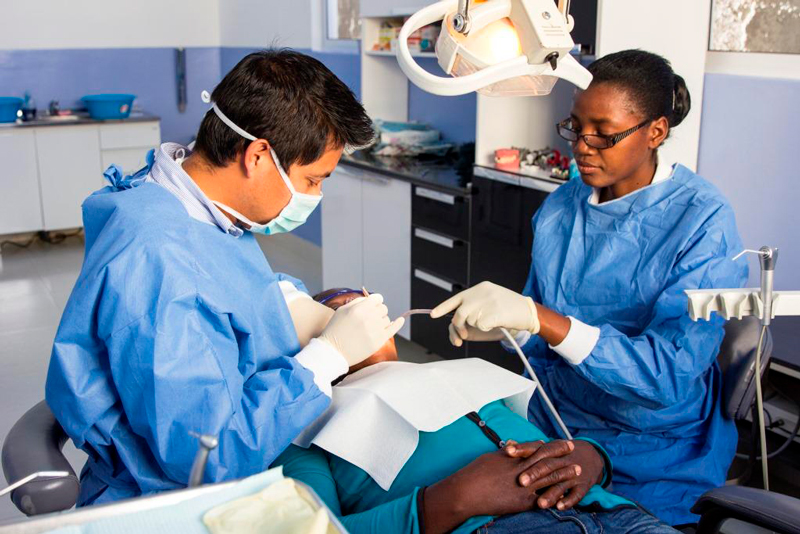 Volunteer doctors doing dentistry on patient
