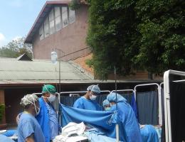 Photo taken the day of the earthquake: Drs. Vidya Prodhananga, OB-GYN, and Ramon Ruiz Diaz, anesthesiologist, and their team perform a cesarean section outside of Scheer Memorial during the aftershocks of the earthquake.